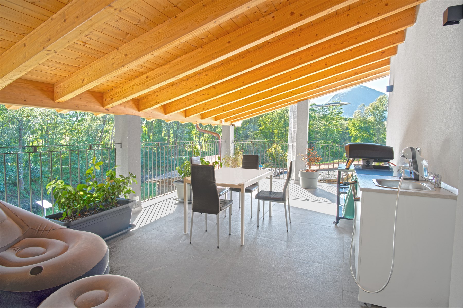 Terrazza coperta con travi in legno e vista sul verde